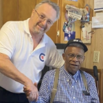 白色CPC候选人史蒂文·科特（Steven Cotter）握住新格拉斯哥的黑人居民福斯特（Foster Elms）的手。