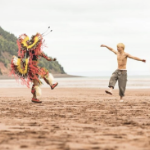 土着仪式礼服的一个人和男孩在米纳斯盆地的红沙子海滩跳舞。