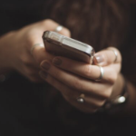 颜色妇女使用的手机的特写镜头，有很多凉快的银色戒指