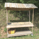 An empty farm cart, handmade from pine with a peaked roof