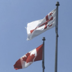 在晴朗的日子里，加拿大国旗和米克马克大议会的红白旗帜并排飘扬