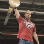 JP西姆斯在他的头上举着一个金质奖杯腰带