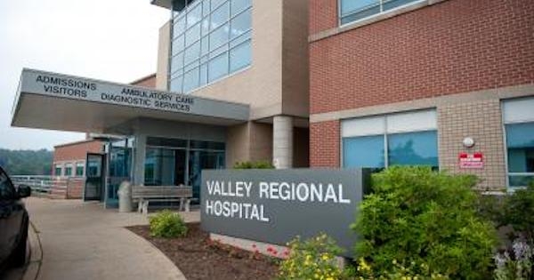 山谷地区医院的入口，是一座红砖和米色混凝土建筑。