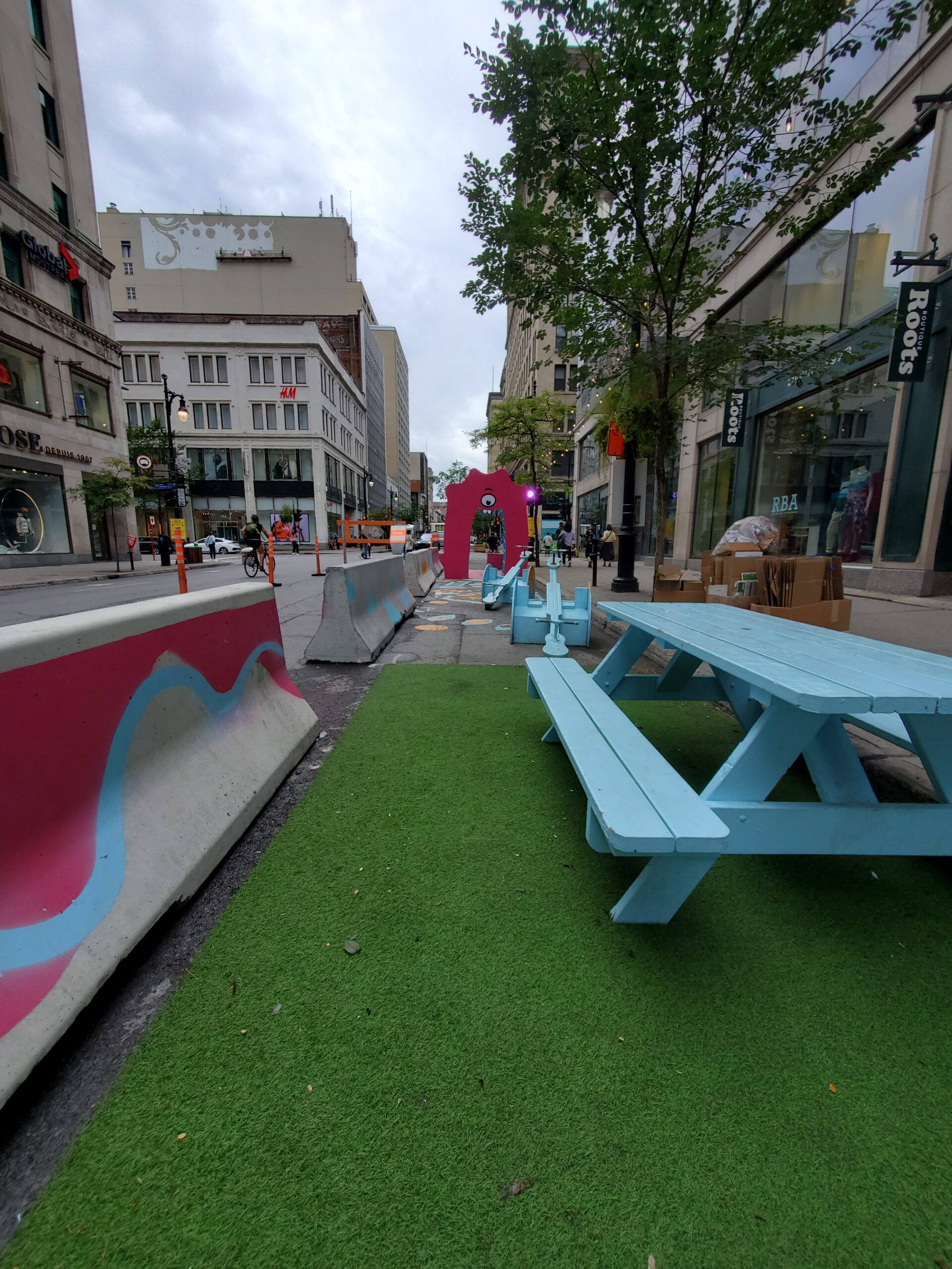 假草坪地毯，野餐桌和混凝土路障在街道上
