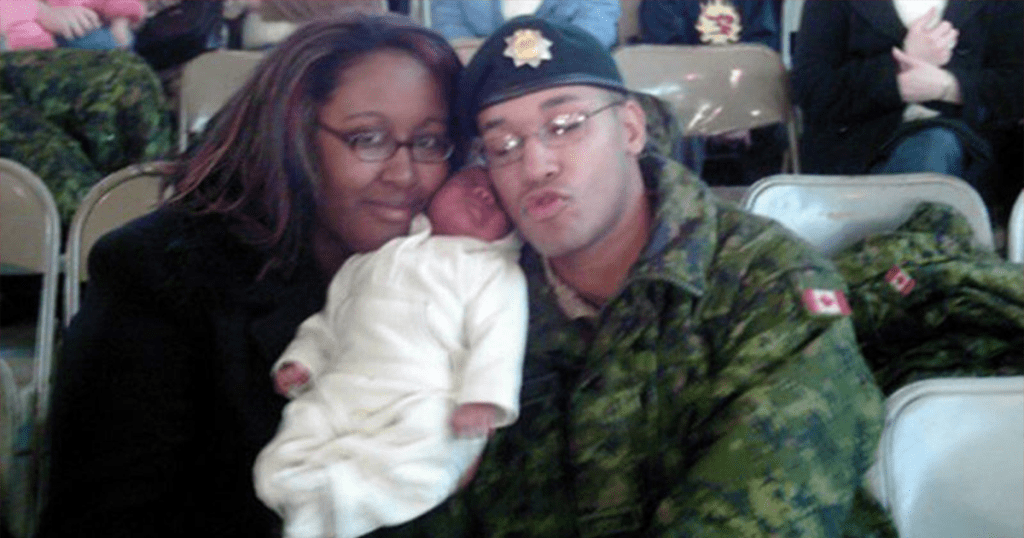 A photo of Shanna, Aaliyah and Lionel Desmond. Shanna is holding Aaliyah who is an infant dressed in a white sleeper. Lionel is wearing his military fatigues.