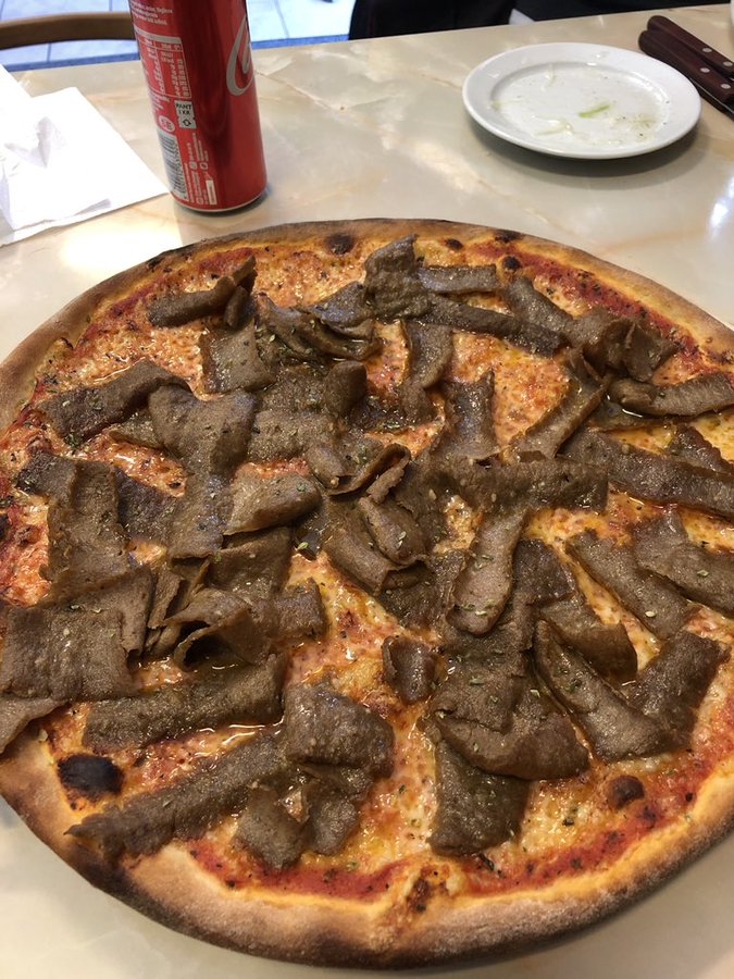 披萨上面有薄肉片，不加奶酪。