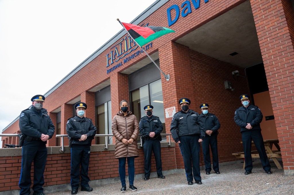 哈利法克斯警方在2021年2月的推特帖子中纪念非洲遗产月。几名哈利法克斯地区警察站在哥廷根大街警察总部的台阶上。红色、绿色和黑色条纹的非洲新斯科舍省国旗在他们上方飘扬。