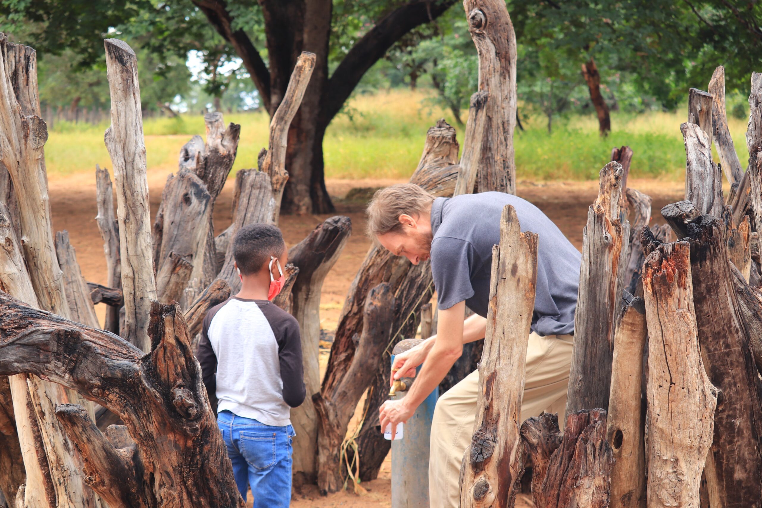 Rob Parker和Rinaani Musutua的儿子从recon钻井区附近的钻孔中采集水样。(贡献)