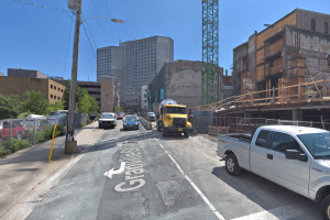 一个谷歌地图街景格兰维尔街向南看，周围是建筑，卡车，汽车和起重机。海事中心在背景中。