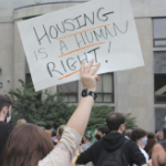 一只手举起了布里斯托尔董事会的标志，说房屋是大写字母中的人权。