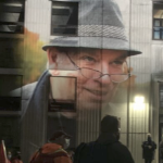 A photo of Robert Devet projected onto the wall of the old library at night