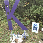 路边的纪念馆，上面有鲜花和大紫色字母K。