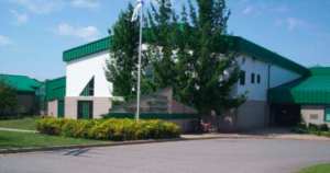 新斯科舍青年中心的照片在沃特维尔。这座建筑是白色的绿色饰边。几棵树被种植出来。