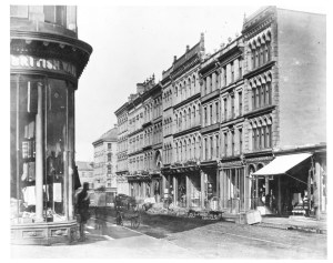 一张黑白照片显示了杜克和格兰维尔街拐角处的特写。街角的一栋建筑有一个可爱的圆形商店橱窗。