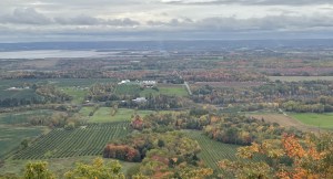 这是一张从安纳波利斯山谷望去的照片，下面是农田和其他财产的拼凑。米纳斯盆地在远处，树木呈现出秋天的红色、橙色和金色。