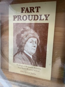 沃尔夫维尔一家二手商店橱窗里陈列着一本名为《骄傲地放屁》的书。这本书的封面上有一张照片，一个戴着皮帽和圆形眼镜的男人可能会为他的屁感到骄傲。