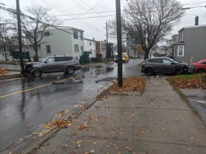 在罗伊街上碰撞的后果，其中一辆车跑到另一辆车。在这里，汽车位于交叉口的相对侧面。每辆车的前端都受到严重损坏。这是一个下雨天，街道湿了，地上有叶子。