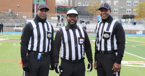 三名黑人足球裁判对着镜头微笑。