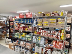 达特茅斯北基督教食品银行货架上不易腐烂食物的照片。这里有盒装的卡夫正餐、罐装金枪鱼和罐装蔬菜。