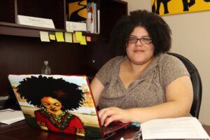 ANSDPAD联盟主任瓦妮莎·费尔斯在办公室用笔记本电脑工作时对着镜头微笑。