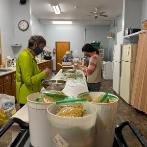 北达特茅斯外展资源食品银行的志愿者在厨房重新包装散装商品。