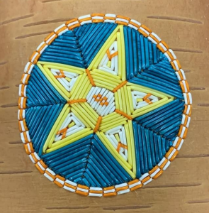 五角星染色豪猪羽毛在桦树皮。这件作品的主色调是黄色和蓝色。