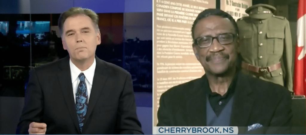 左边是CTV新闻主播兼记者布鲁斯·弗里斯科的照片，他穿着深色西装，打着领带。右边是身穿深灰色西装、黑色衬衫、灰色背心的道格拉斯·拉克的照片。Ruck在一个博物馆里，他身后是关于军事历史和军装的展览。