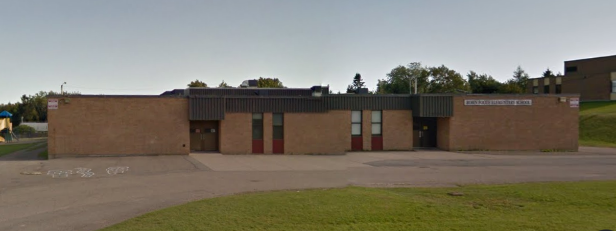 街景图片的截图显示一个低挂砖学校设置在停车场后面。