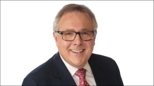 CTV主持人史蒂夫·墨菲是一个微笑的人，戴着眼镜，黑色西装外套，白色衬衫，粉红色领带。