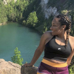 一个黑人妇女从一个高高的悬崖上俯瞰湖面