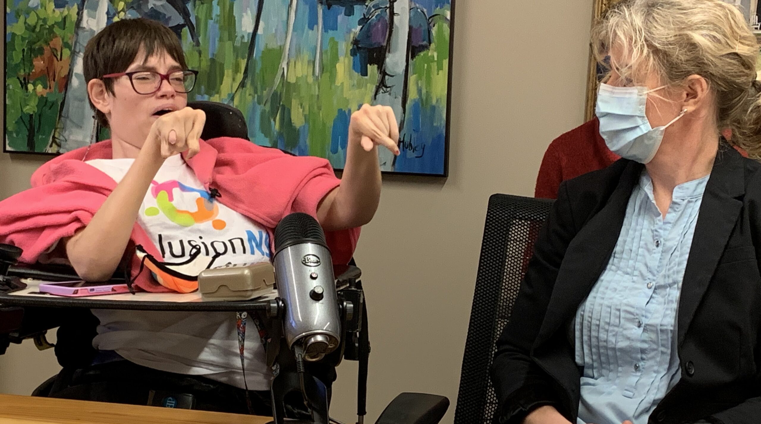 两个女人坐在麦克风前