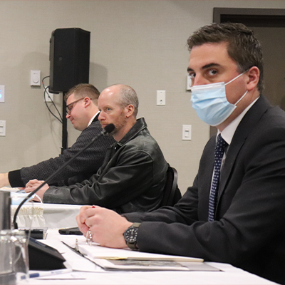 斯科特·马丁警官，杰森·迈斯纳警官，以及助理检察官安德鲁·高夫的律师。高夫戴着蓝色一次性口罩，侧眼看着摄像机。图片:Matthew Byard。