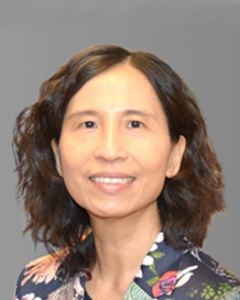 微笑的特蕾莎·谭医生爆头。她留着齐肩的棕色头发，穿着一件印花上衣。