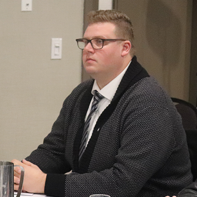 身材魁梧、戴眼镜的白人男子凝视着前方。