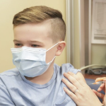 一个11岁以下的年轻白人男孩接受了他的第一次疫苗接种