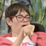 坐在轮椅上的年轻女子维姬·莱瓦克(Vicky Levack)在一次公众集会上发言