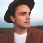 布雷登·林(Braden Lam)是一个看起来很严肃的年轻白人，戴着一顶很酷的软呢帽，穿着酒红色夹克