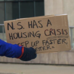 一名抗议者的标语上写着“新斯科舍省面临住房危机”