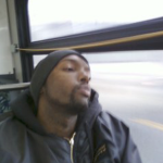 一个年轻而疲惫的黑人坐公共汽车