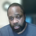 柯克·约翰逊（Kirk Johnson），一个穿着蓝色毛衣的黑人