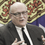 Dr. robert Strang gestures at a press conference.
