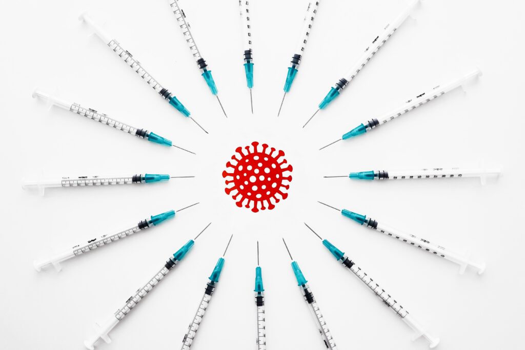 红色冠状病毒的插图，带有独特的尖峰，周围环绕着圆圈，尖端针对该风格化病毒。