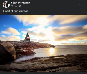 一张ps过的照片，会说话的胡迪圣诞树坐在佩吉湾黑色光滑的岩石上。