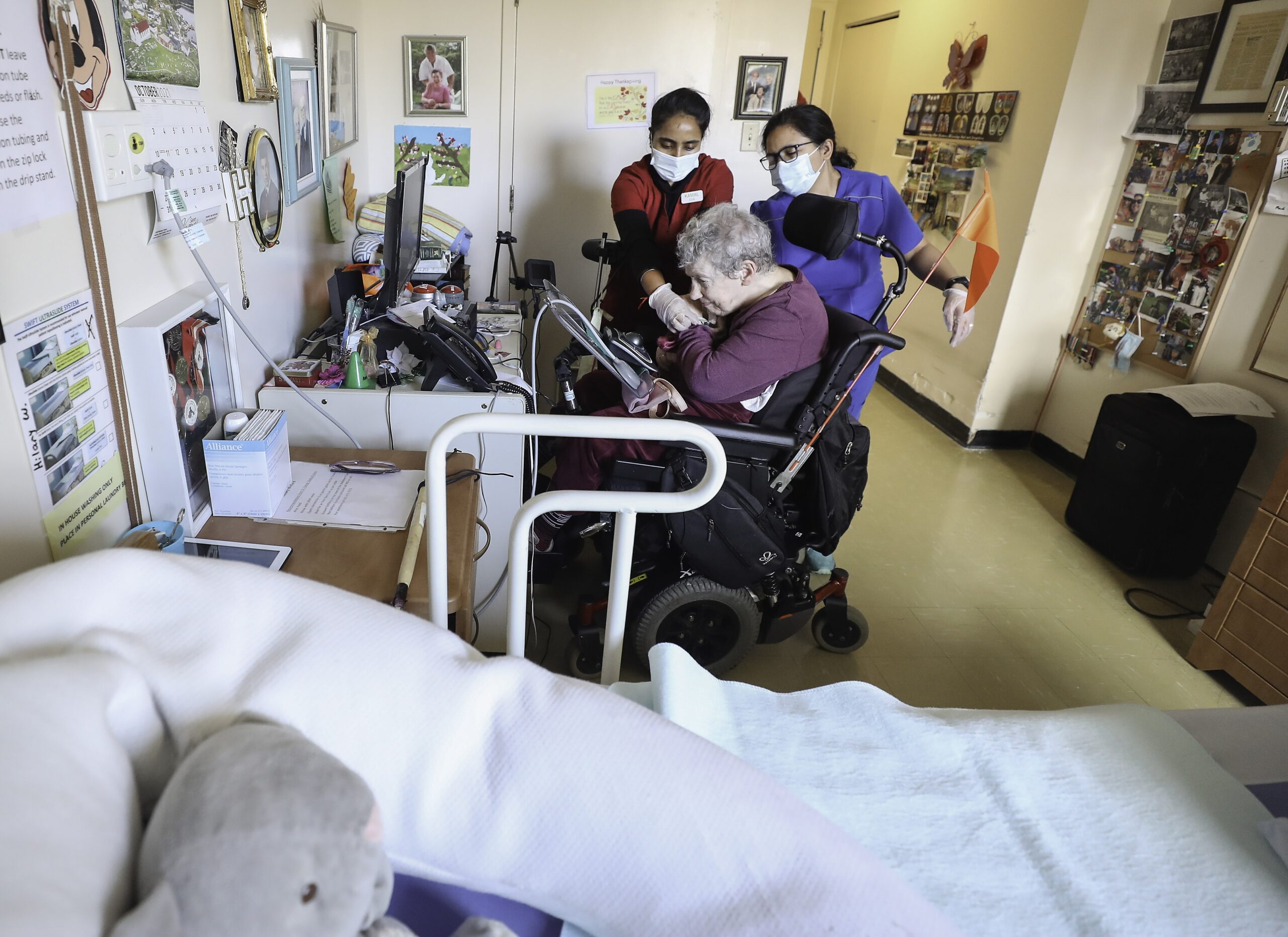 two women assist an elderly woman