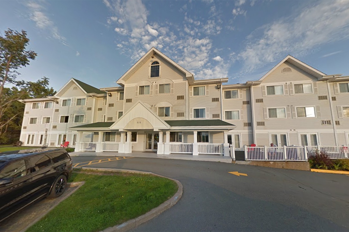 在阳光灿烂的日子里，黄金时段可以看到一座灰色的建筑。这座建筑是一座旅馆，有三座山峰和几扇窗户。前门有个悬檐。天空中有缕缕云。