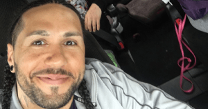 带着小辫微笑的黑人男子的近景