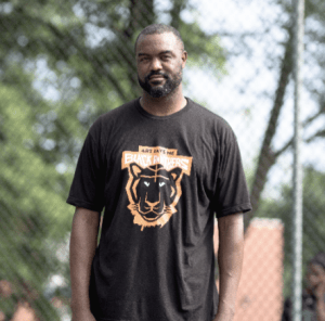 一个穿着黑色t恤的黑人，前面有黑豹图案。