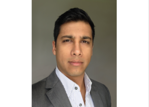 一名穿着西装外套和正装衬衫的严肃男子盯着镜头。