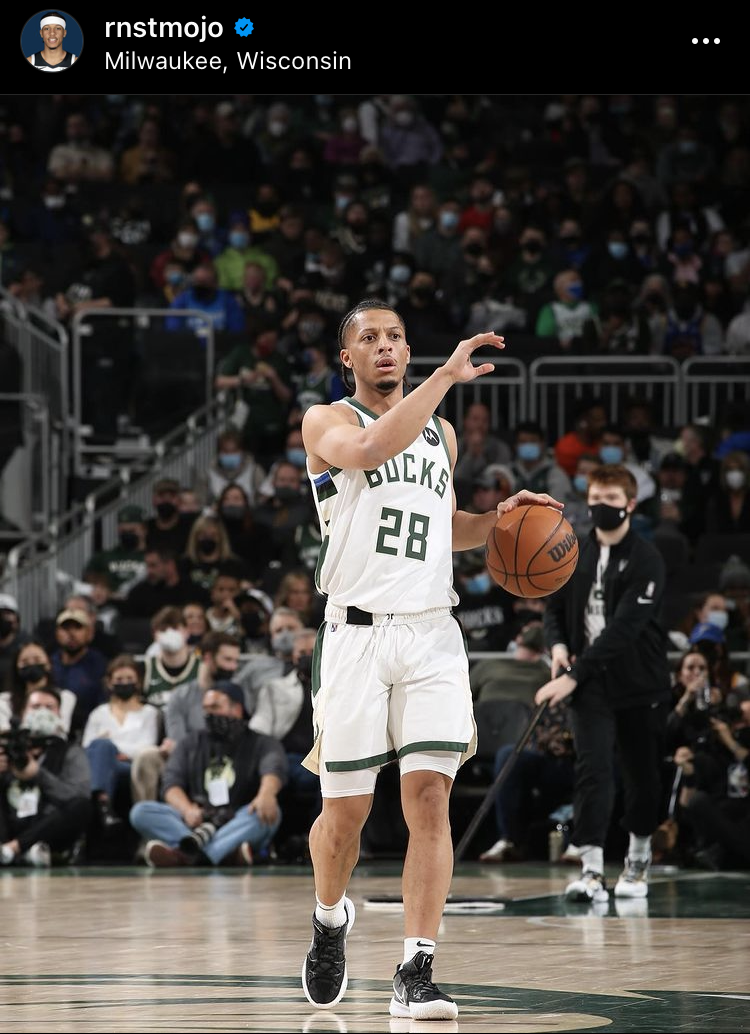 黑人篮球运动员带着球上了球场，他穿着前面印有28号的白色主场球衣