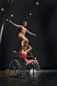 两个马戏团演员，其中一个坐在轮椅上，表演特技。